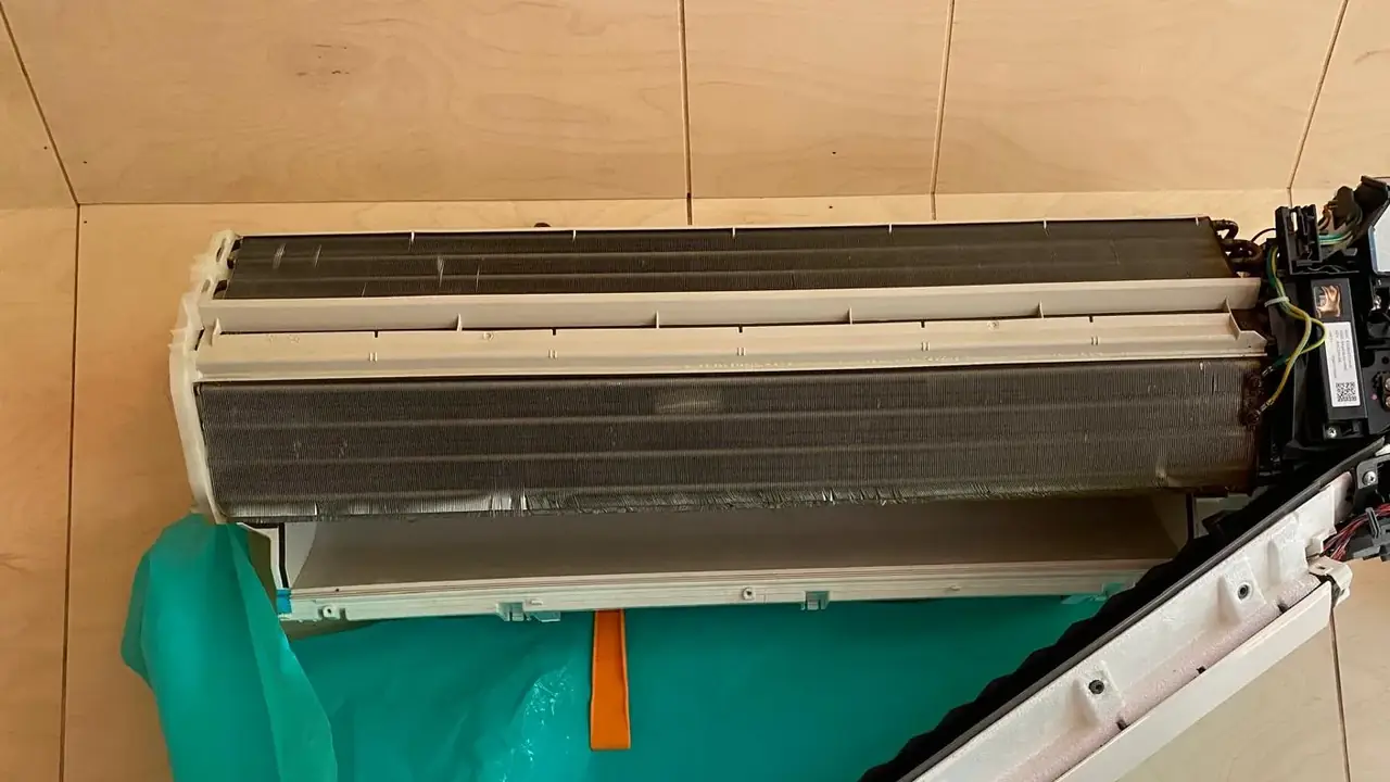Opengewerkt binnendeel met blote verdamper en een reinigingshoes eronder die het spoelwater opvangt.